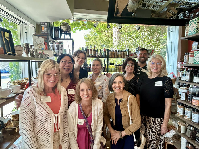 Corporate group gathered for a private tasting event surrounded by olive oils at Olive 'n Vinnie's Glen Ellyn