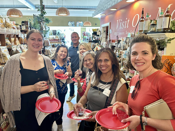 Event guests holding tasting plates and sampling balsamic vinegars at Olive 'n Vinnie's in Glen Ellyn
